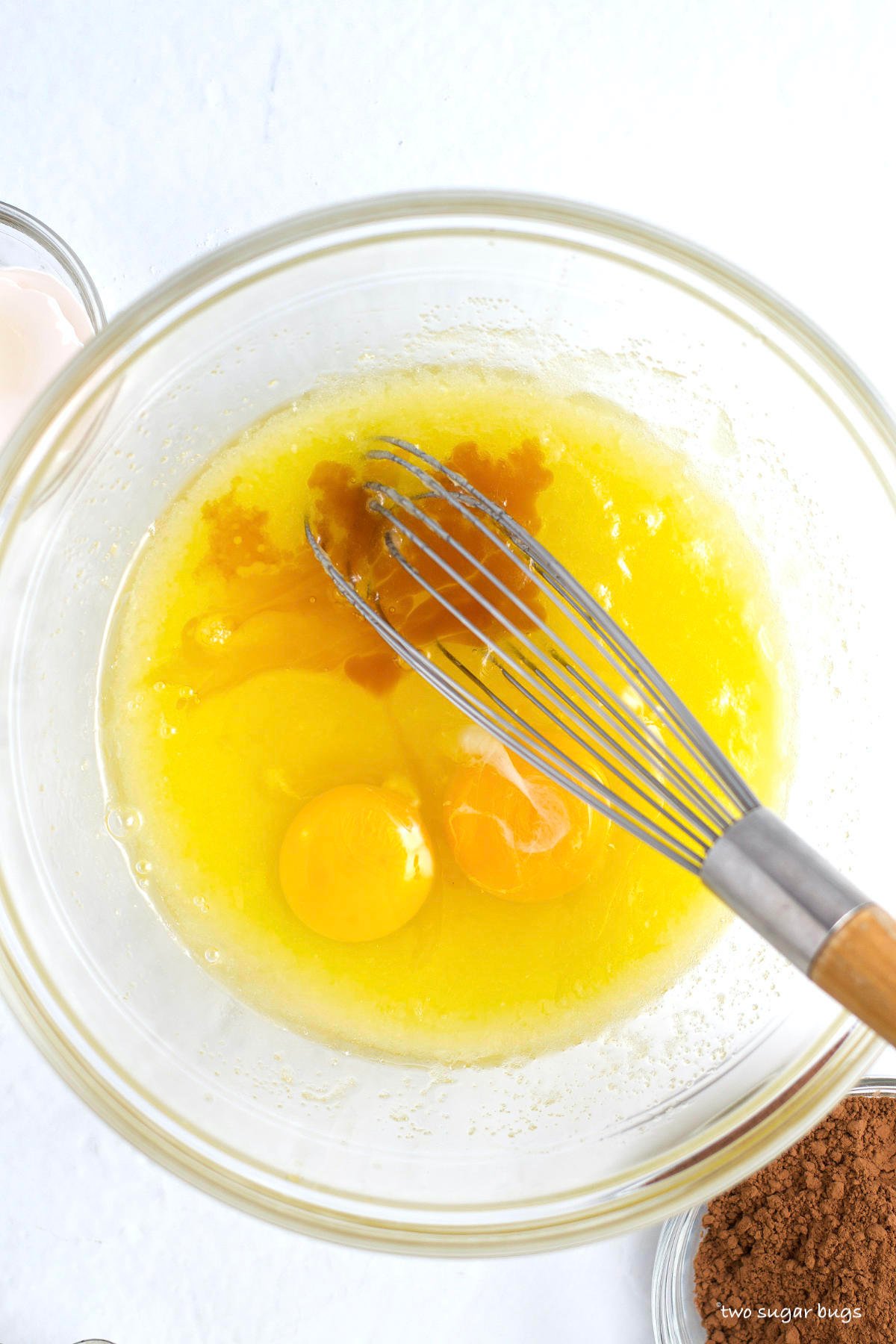 eggs and vanilla on top of melted butter and sugar