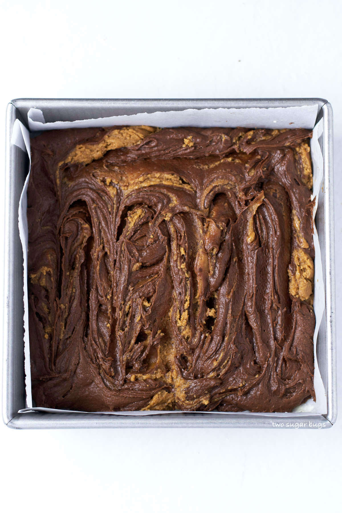 cookie butter fudge swirled into brownie batter in a baking pan